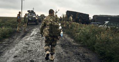 Ukrainian soldiers stand on the road in the freed territory of the Kharkiv region, Ukraine, Sept. 12, 2022. (AP Photo)