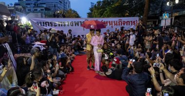 Pro-democracy protesters perform on a mock "red carpet" fashion show billed as a sort of counterpoint to a fashion show being held by one of the monarchy's princesses nearby in Bangkok, Thailand, Oct. 29, 2020. (AP Photo)