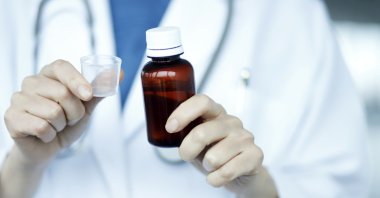 A doctor holding medical syrup. (Shutterstock File Photo)