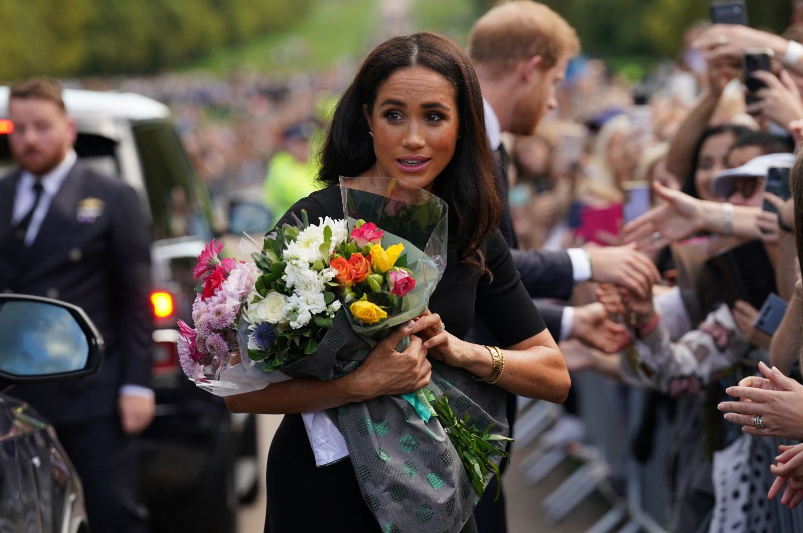 Meghan, Duchess of Sussex collects flowers as she chats with well-wishers on the Long walk at Windsor Castle, two days after the death of Britain&#039;s Queen Elizabeth II at the age of 96, Berkshire, U.S., Sept.10, 2022. (AFP Photo)