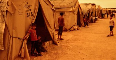 Children stand outside their tents at a camp for displaced people during a sandstorm in Idlib, Syria, June 2, 2022. (Reuters Photo)