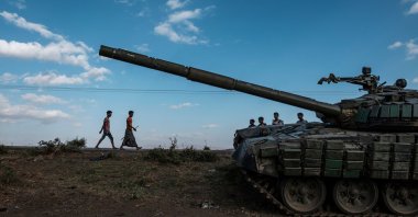 Youngsters walk next to an abandoned destroyed tank south of the town of Mehoni, Ethiopia, Dec. 11, 2020. (AFP Photo)