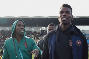 This file photo shows France national team player Paul Pogba (R) and his brother Mathias Pogba (L) walking on the pitch prior to a football match between All Star France and Guinea at the Vallee du Cher Stadium in Tours, central France, as part of the "48h for Guinea" charity event, Dec. 29, 2019. (Photo by GUILLAUME SOUVANT / AFP)