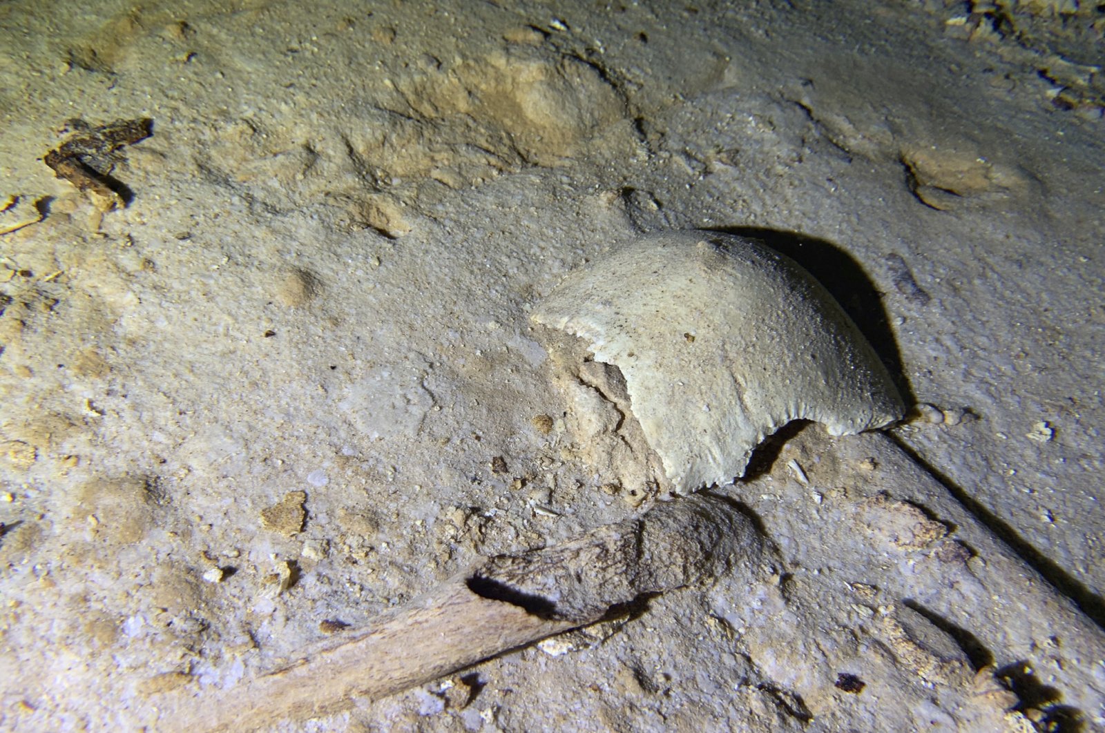 This photo courtesy of Octavio del Rio shows fragments of a pre-historic human skeleton partly covered by sediment in an underwater cave in Tulum, Mexico, Sept. 10, 2022. (AP Photo)