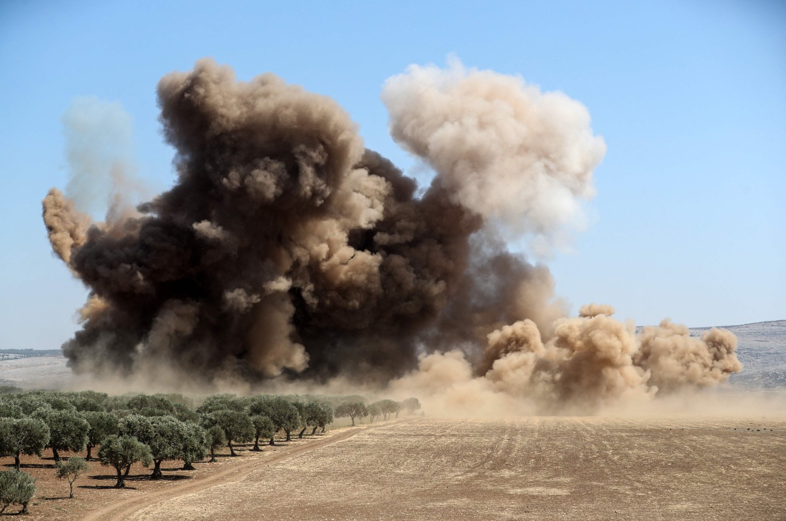 Dust and smoke rise during a reported Russian forces bombing, in the Syrian opposition-held western countryside of Idlib, Sept. 8, 2022. (AFP Photo)