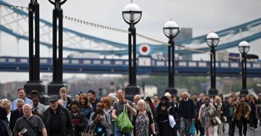 Members of the public stand in the queue on the South Bank of the River Thames, near Tower Bridge, as they wait in line to pay their respects to the late Queen Elizabeth II, in London, U.K. Sept. 15, 2022. (AFP Photo)