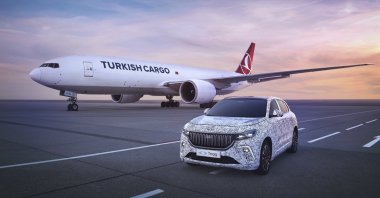 This illustration photo shows a Togg SUV model alongside a Turkish cargo plane. (AA Photo)