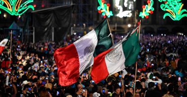 People watch Mexican music group Los Tigres del Norte, perform during the ceremony "The Shout" (El Grito) marking the start of Independence Day celebrations at the Zocalo square in Mexico City, Sept. 15, 2022. (AFP Photo)