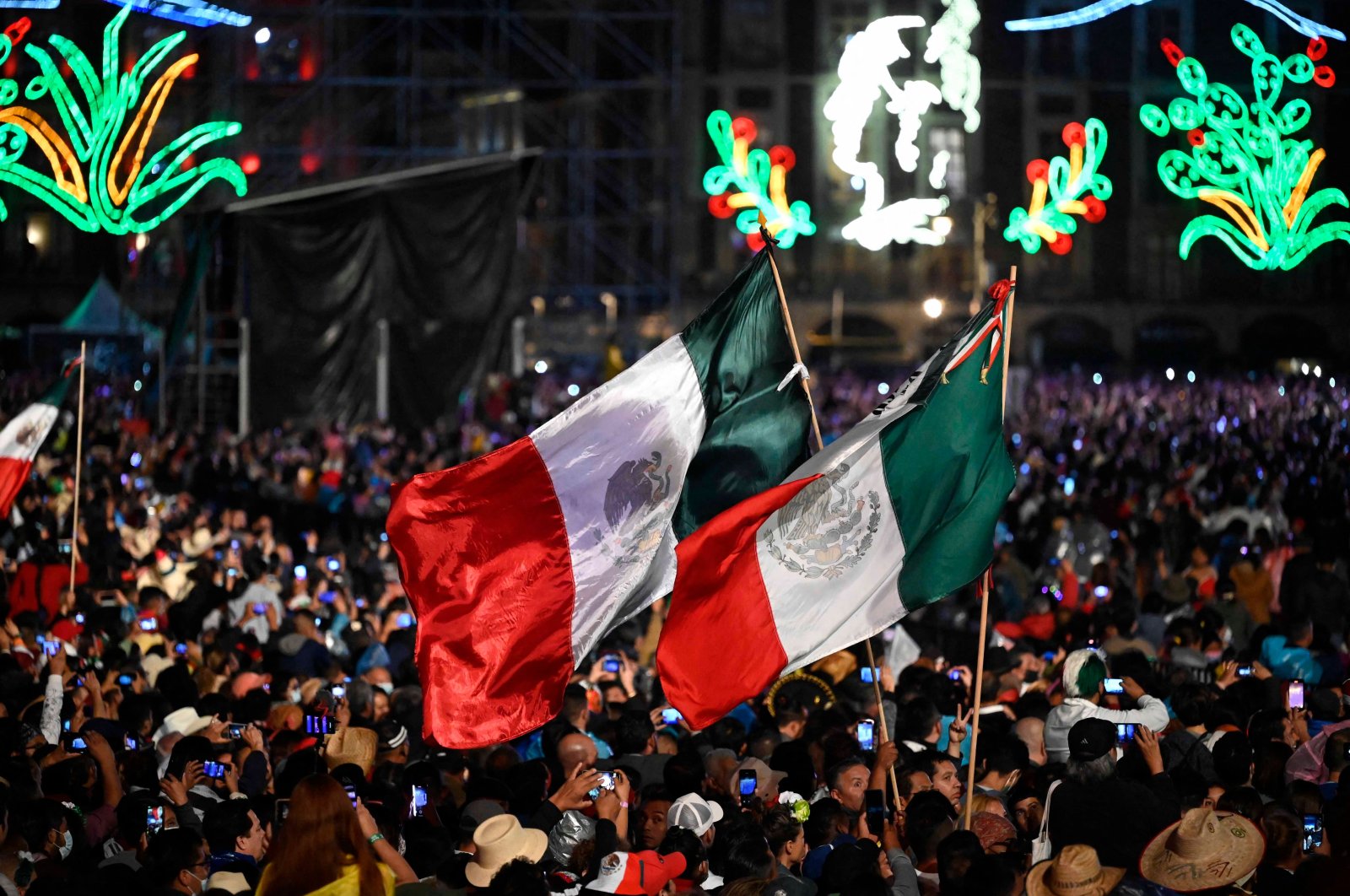 People watch Mexican music group Los Tigres del Norte, perform during the ceremony &quot;The Shout&quot; (El Grito) marking the start of Independence Day celebrations at the Zocalo square in Mexico City, Sept. 15, 2022. (AFP Photo)