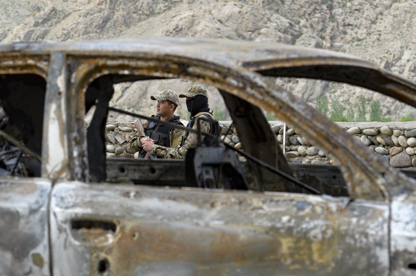 Kyrgyz soldiers are seen behind a burnt vehicle outside the village of Kok-Tash near the Kyrgyzstan-Tajikistan border in southwestern Kyrgyzstan, about 440 kilometers (275 miles) southwest of Bishkek, Kyrgyzstan, May 5, 2021. (AP File Photo)