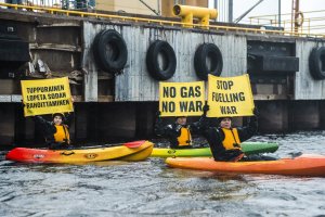 Greenpeace activists hold signs as they block a Russian fossil gas shipment from being offloaded in Tornio, Finland, Sept. 17, 2022. (REUTERS PHOTO)