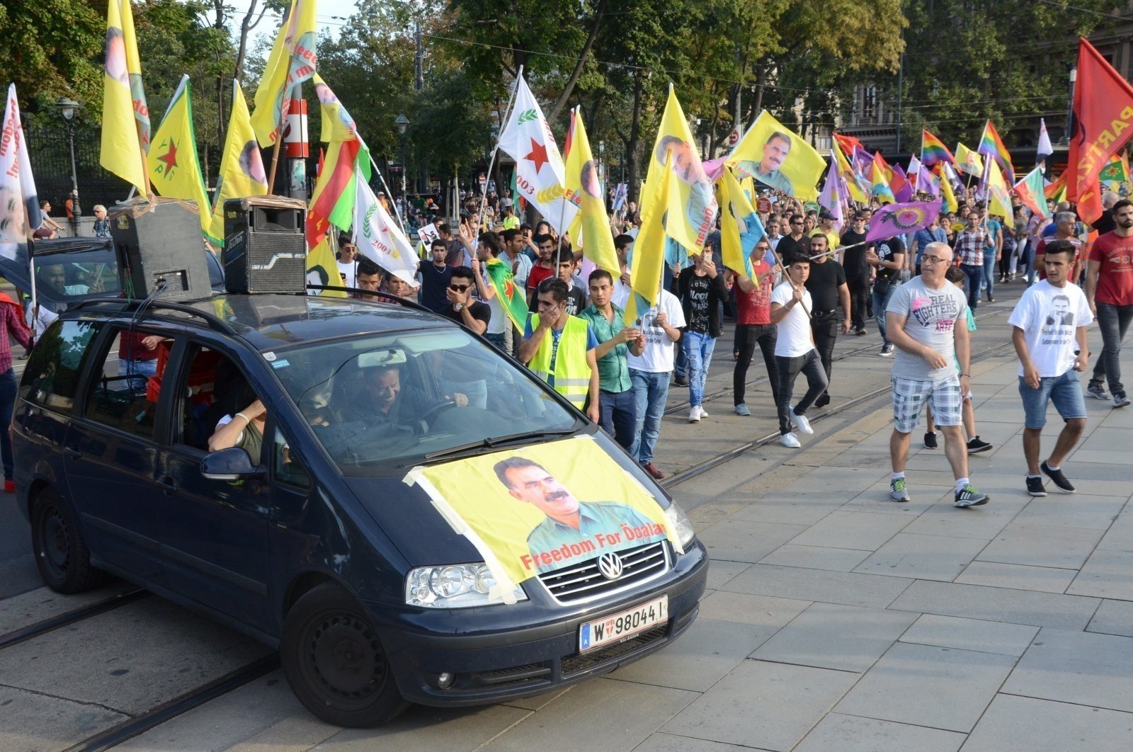 Pro-PKK protesters wave flags of the terrorist group and a picture of imprisoned terrorist leader Abdullah Öcalan is seen on a vehicle, Vienna, Austria, June 28, 2020. (AA Photo)