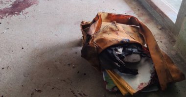 A school bag lies next to dried blood stains on the floor of a middle school in Let Yet Kone village in Tabayin township in the Sagaing region of Myanmar, Sept. 17, 2022. (AP Photo)