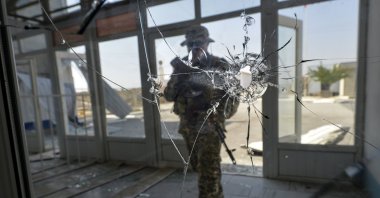 A Kyrgyz soldier enters a checkpoint damaged after fighting on the border between Kyrgyzstan and Tajikistan, in the village of Kyzyl-Bel 950 kilometers (593 miles) southeast of Bishkek, Kyrgyzstan, Sept. 19, 2022. (AP Photo)