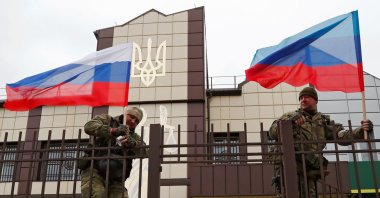 Pro-Russian militia hoist flags of Russian and separatist flags in Stanytsia Luhanska, Ukraine, Feb. 27, 2022. (Reuters Photo)