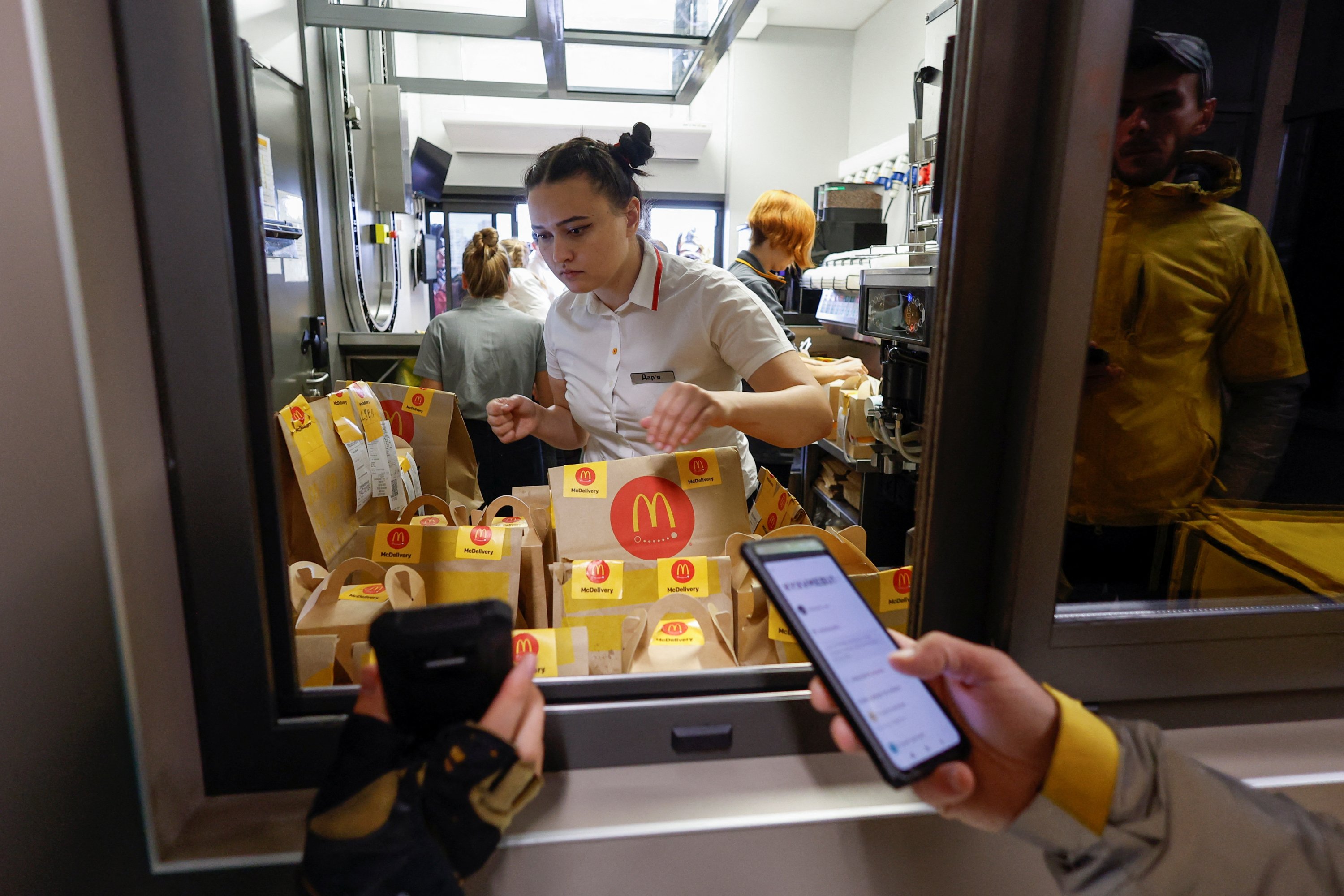Seorang karyawan McDonald memeriksa pesanan sebelum menyerahkannya ke kurir pengiriman makanan Glovo di dalam sebuah restoran, setelah rantai dibuka kembali di tengah serangan Rusia di Ukraina, di Kyiv, Ukraina, 20 September 2022. (Foto Reuters)