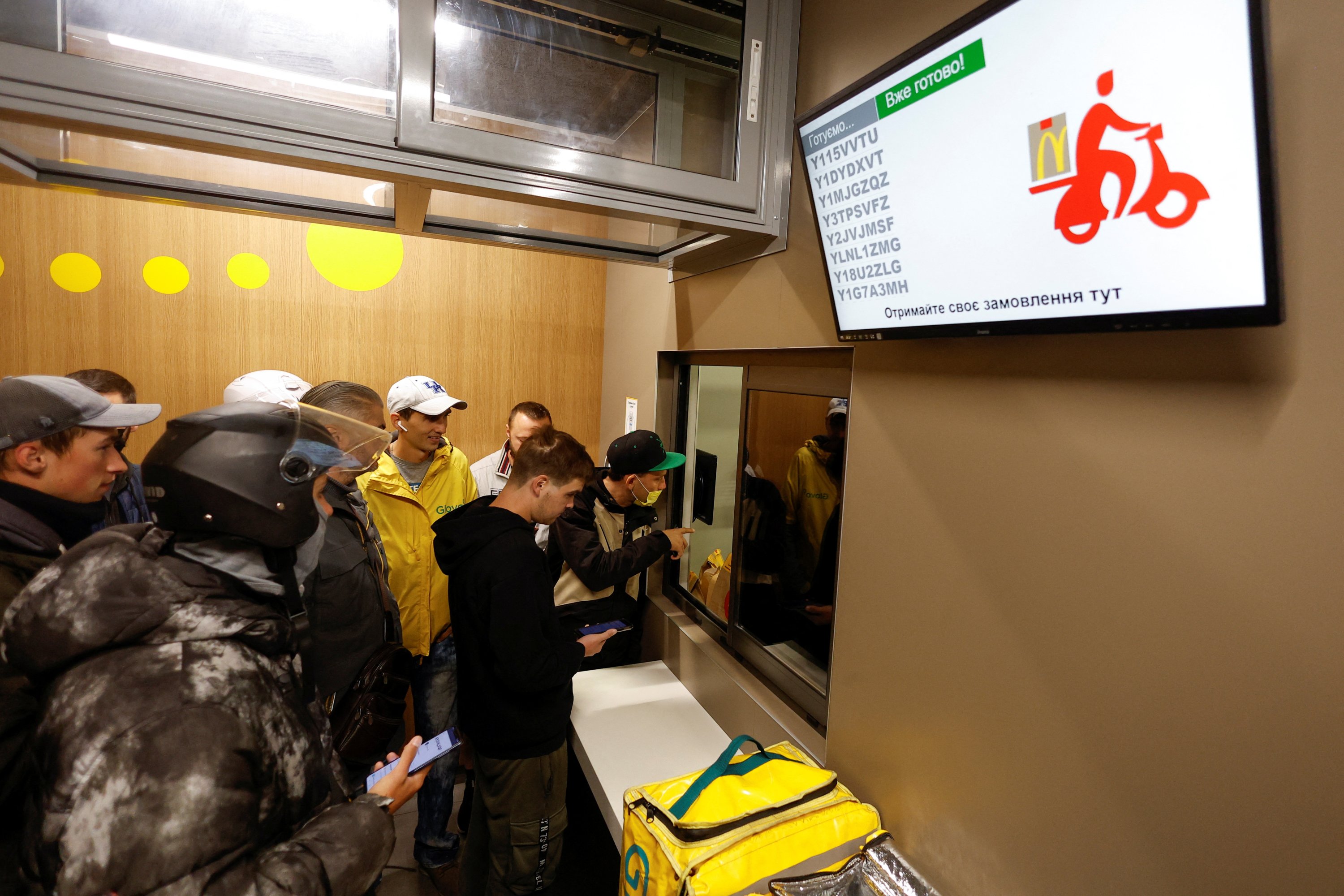 Kurir pengiriman makanan Glovo menunggu untuk mengambil pesanan di dalam restoran McDonald's, setelah rantai dibuka kembali di tengah serangan Rusia di Ukraina, di Kyiv, Ukraina, 20 September 2022. (Foto Reuters)