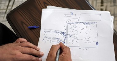 Mutassem Abd al-Sater, a 42-year-old former inmate of Sednaya prison, draws a rudimentary sketch of the prison plan during an interview at his house in Reyhanlı in Türkiye's southern Hatay province near the border with Syria, Aug. 10, 2022. (AFP Photo)
