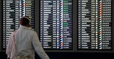 A man looks at a flight information board at the departure zone of Vnukovo International Airport in Moscow, Russia, Dec. 30, 2020. (Reuters Photo)