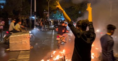 A demonstrator raises his arms during a protest for Mahsa Amini, Tehran, Iran, Sept. 19, 2022. (AFP Photo)