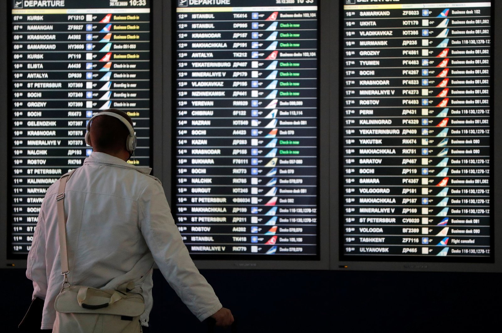 A man looks at a flight information board at the departure zone of Vnukovo International Airport in Moscow, Russia, Dec. 30, 2020. (Reuters Photo)