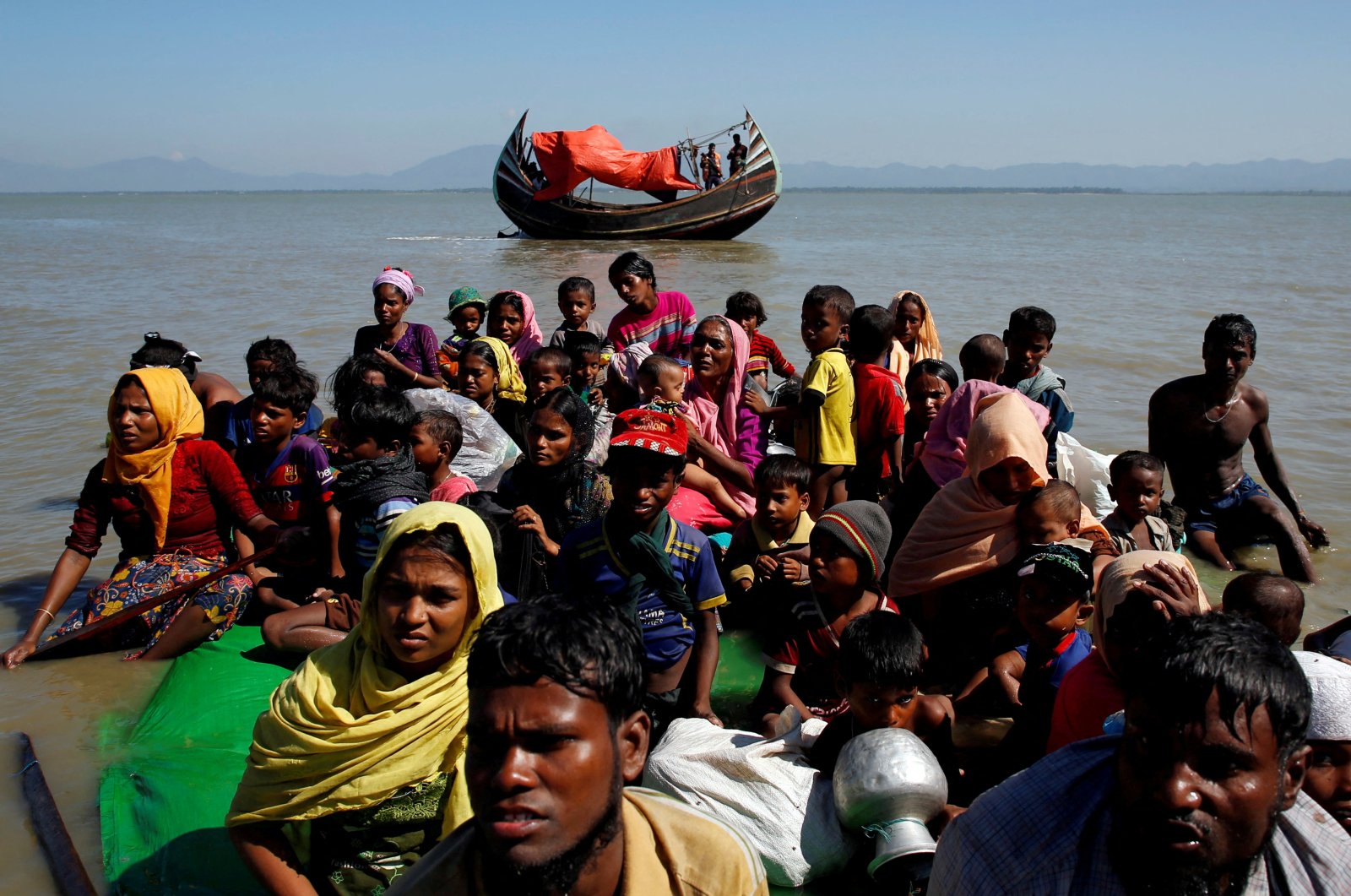 Rohingya refugees sit on a makeshift boat as they get interrogated by the Border Guard Bangladesh after crossing the Bangladesh-Myanmar border, at Shah Porir Dwip near Cox&#039;s Bazar, Bangladesh Nov. 9, 2017. (Reuters File Photo)