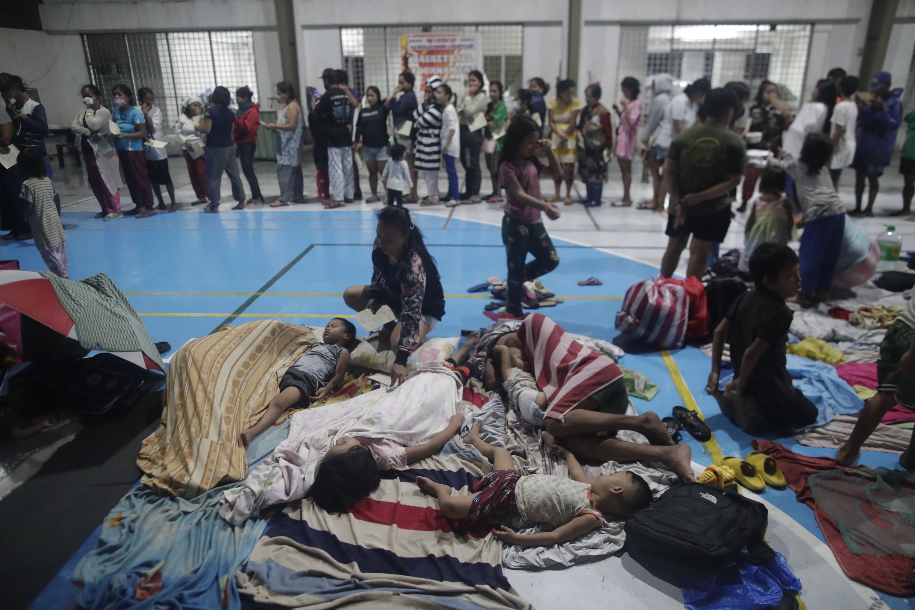 Pengungsi beristirahat di dalam gimnasium yang diubah menjadi pusat evakuasi sementara di Manila, Filipina, 25 September 2022. (EPA Photo)