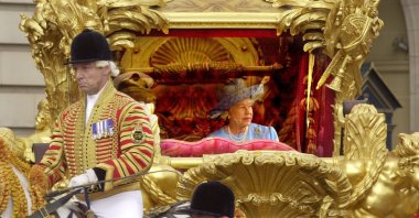 Queen Elizabeth II with her husband Prince Philip, ride in the State Gold Coach en route to St. Paul's Cathedral in London, U.K., June 4, 2002. (AP Photo)