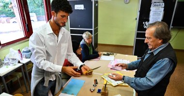 A man (R) prepares to cast his vote at a polling station, Rome, Italy, Sept. 25, 2022. (AFP Photo)