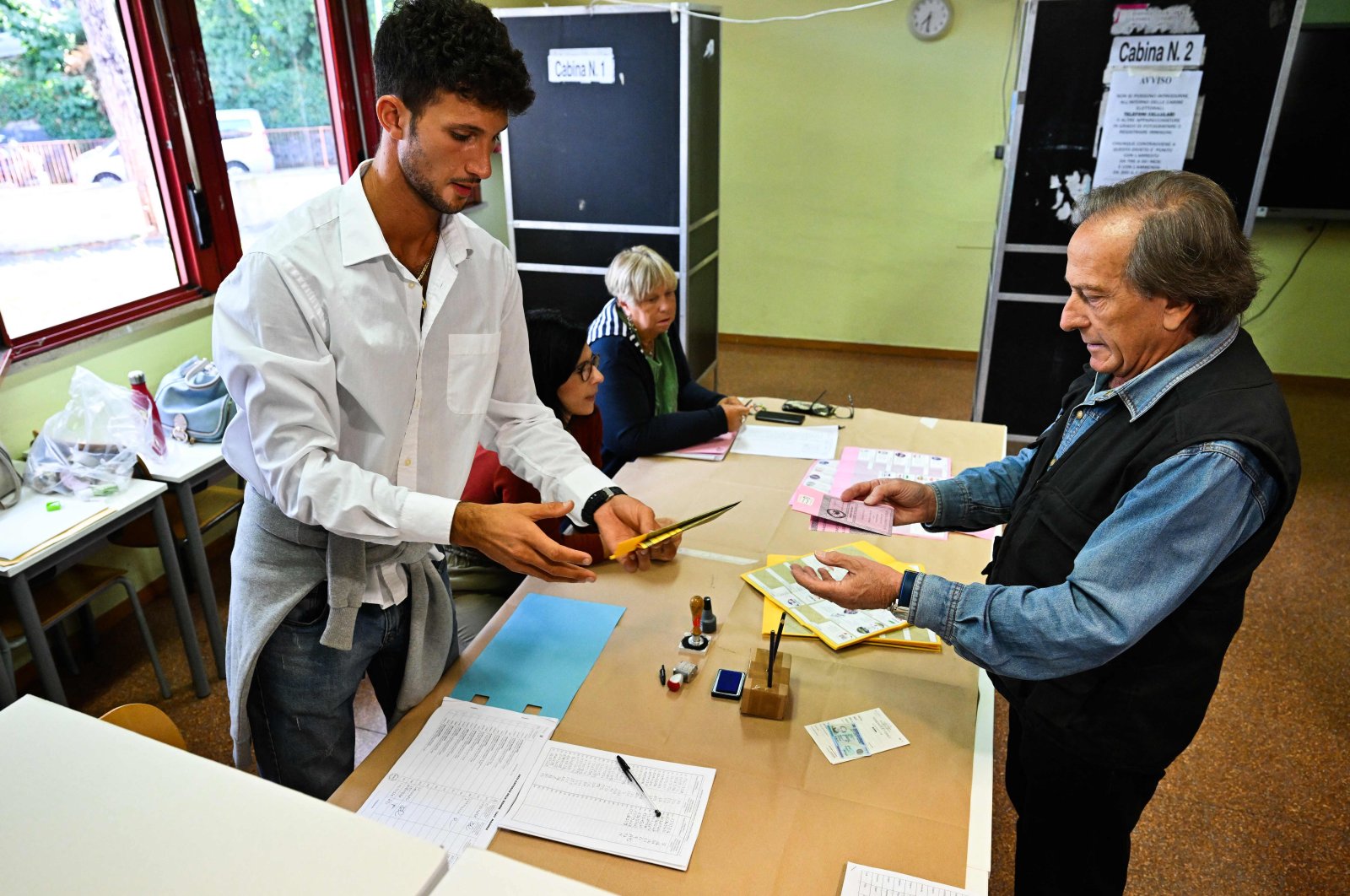 A man (R) prepares to cast his vote at a polling station, Rome, Italy, Sept. 25, 2022. (AFP Photo)