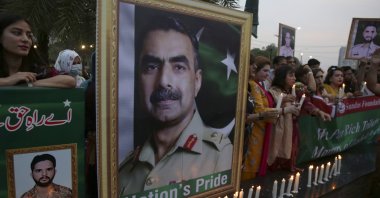 Members of civil society group participate in a candle-light vigil to pay tribute to army officers killed in an earlier helicopter crash, Lahore, Pakistan, Aug. 5, 2022. (AP Photo)