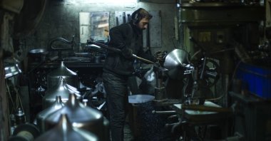 A worker shapes metal pieces for lamps in a workshop in Istanbul, Türkiye, Sept. 22, 2022. (AP Photo)
