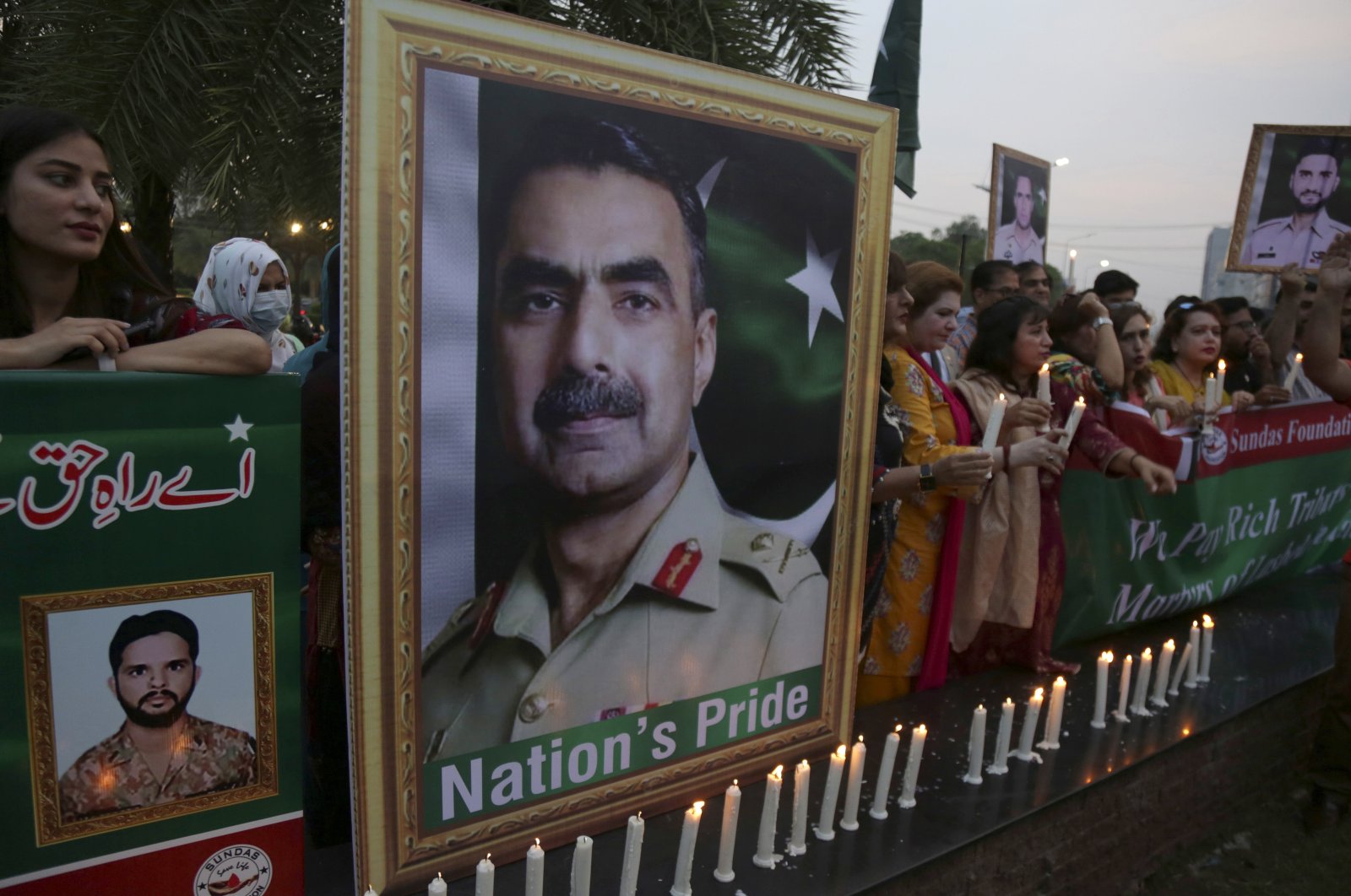 Members of civil society group participate in a candle-light vigil to pay tribute to army officers killed in an earlier helicopter crash, Lahore, Pakistan, Aug. 5, 2022. (AP Photo)