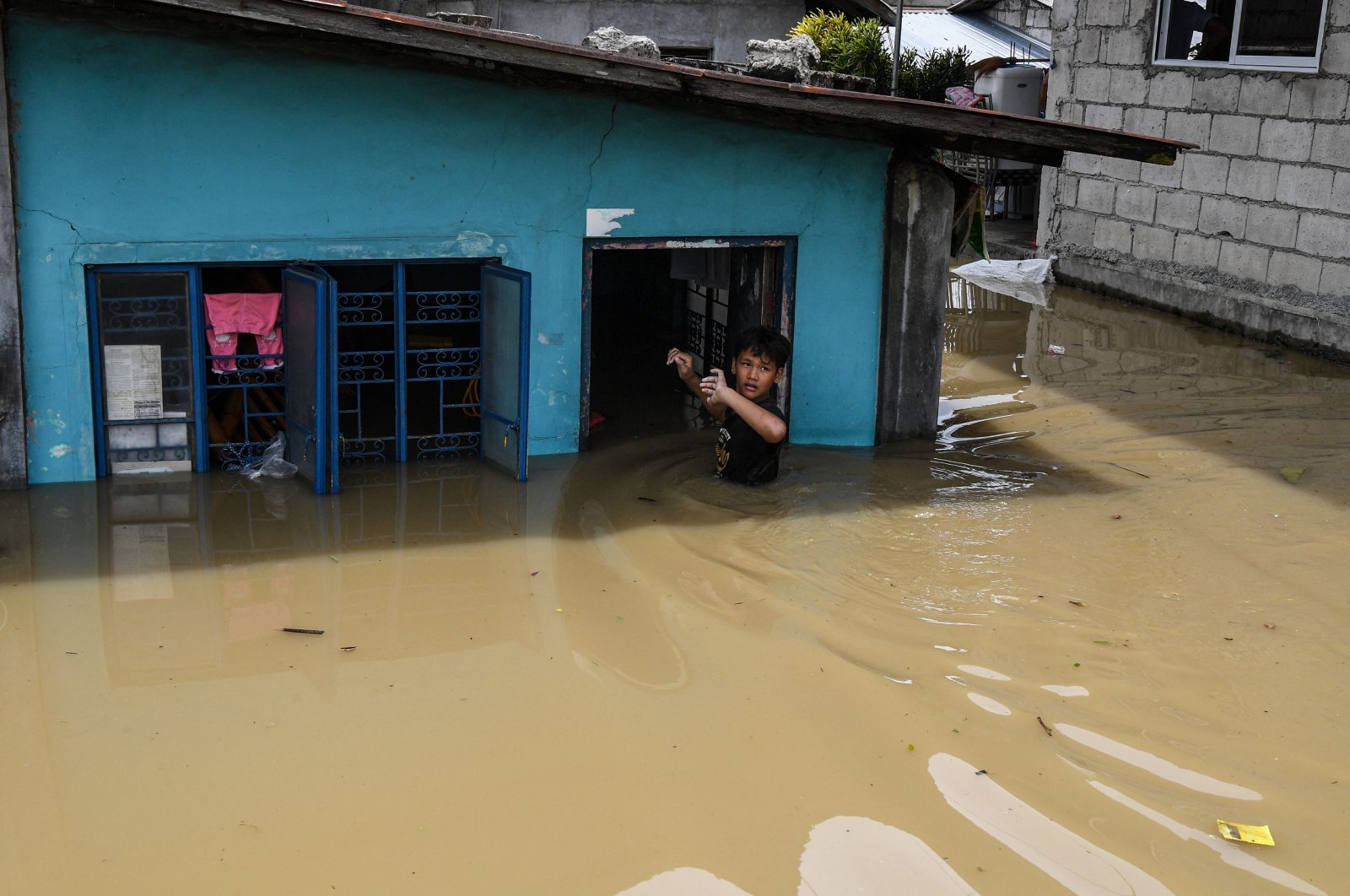 A resident enters his flooded home in the aftermath of Super Typhoon Noru, San Ildefonso, the Philippines, Sept. 26, 2022. (AFP Photo)