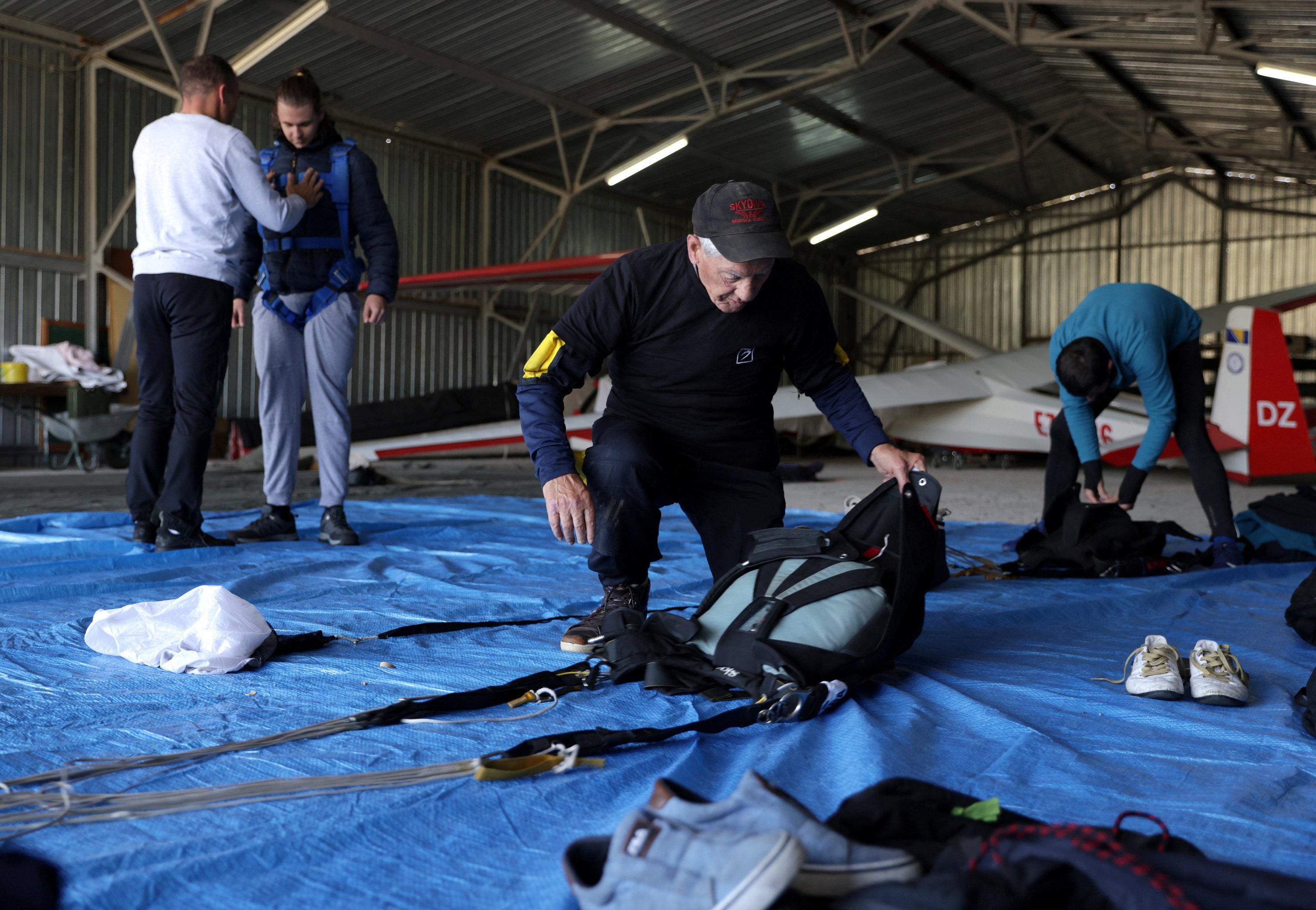 Ibrahim Kalesic, seorang penerjun payung berusia 88 tahun, mempersiapkan parasutnya selama Para Challenge Cup di Bihac, Bosnia-Herzegovina, 24 September 2022. (Foto Reuters)