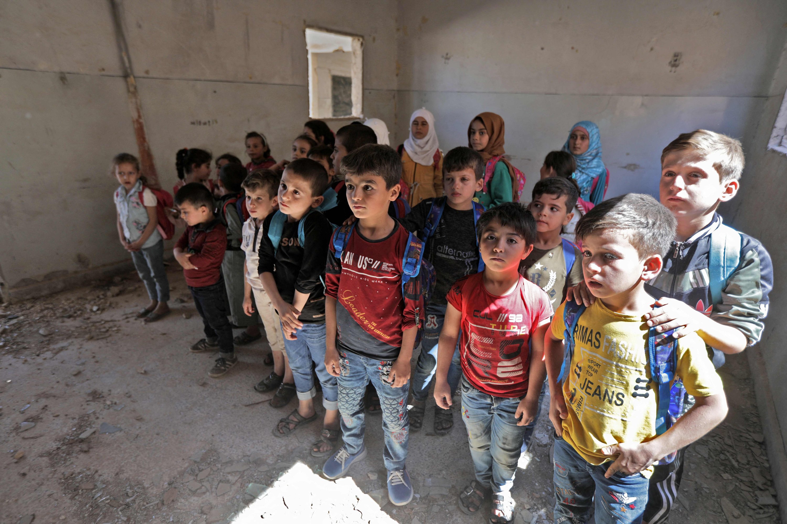 Anak-anak sekolah Suriah berdiri di ruang kelas di sebuah sekolah darurat di sisi oposisi kota Tadif di utara, timur kota Aleppo, Suriah, 26 September 2022. (AFP Photo)