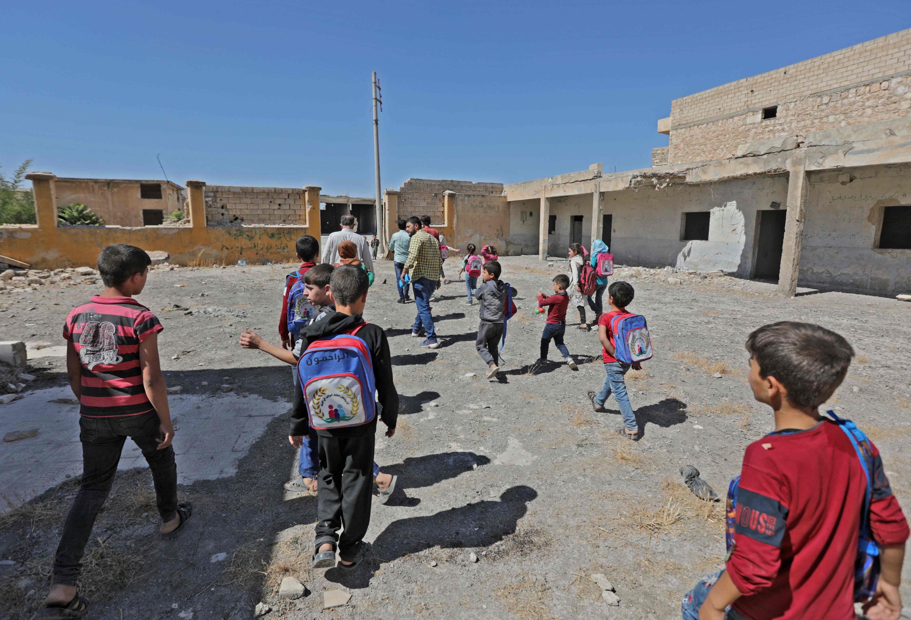 Anak-anak sekolah Suriah berlari ke sekolah darurat mereka di sisi yang dikuasai oposisi di kota Tadif, timur kota Aleppo, Suriah, 26 September 2022. (AFP Photo)