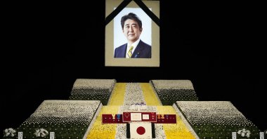 A portrait of ex-Japanese Prime Minister Shinzo Abe hangs on stage at the state funeral of former Japanese Prime Minister Shinzo Abe at Nippon Budokan in Tokyo, Japan, Sept. 27, 2022. (EPA Photo)