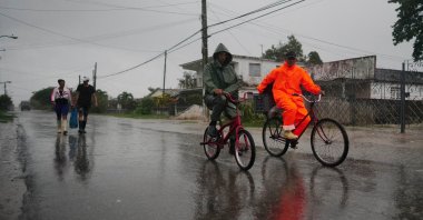 People walk under the rain ahead of the arrival of Hurricane Ian in Coloma, Cuba, September 26, 2022. REUTERS/Alexandre Meneghini ni