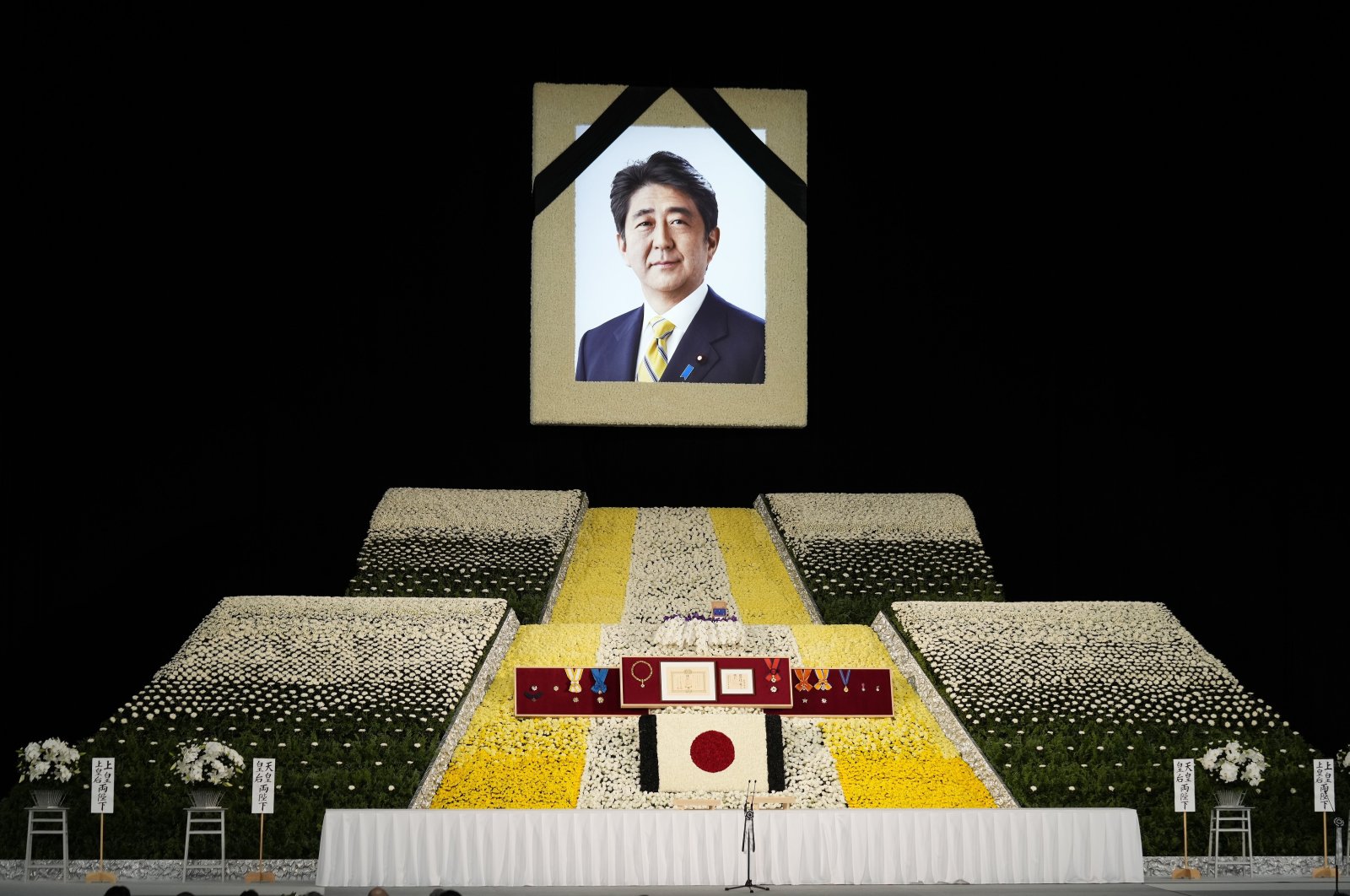 A portrait of ex-Japanese Prime Minister Shinzo Abe hangs on stage at the state funeral of former Japanese Prime Minister Shinzo Abe at Nippon Budokan in Tokyo, Japan, Sept. 27, 2022. (EPA Photo)