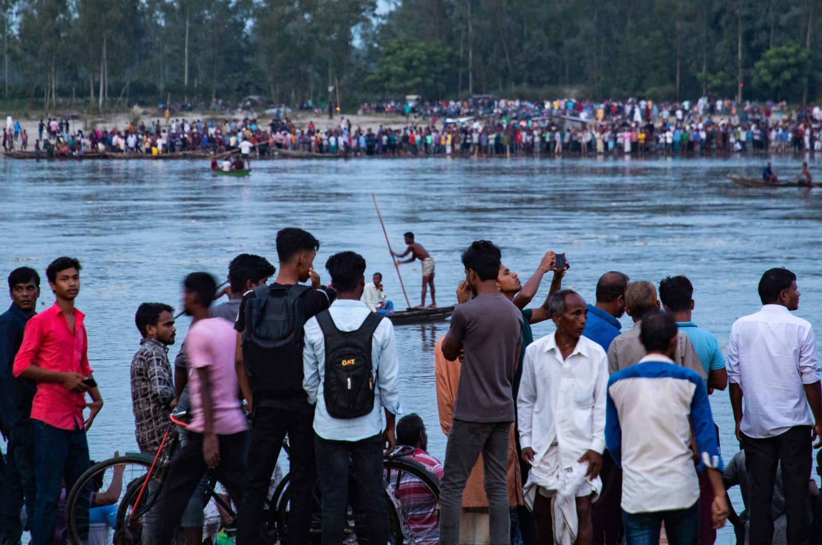 People gather along the banks of the Karatoya river after a boat capsized near the town of Boda, northern Bangladesh, Sept. 25, 2022. (AFP Photo)