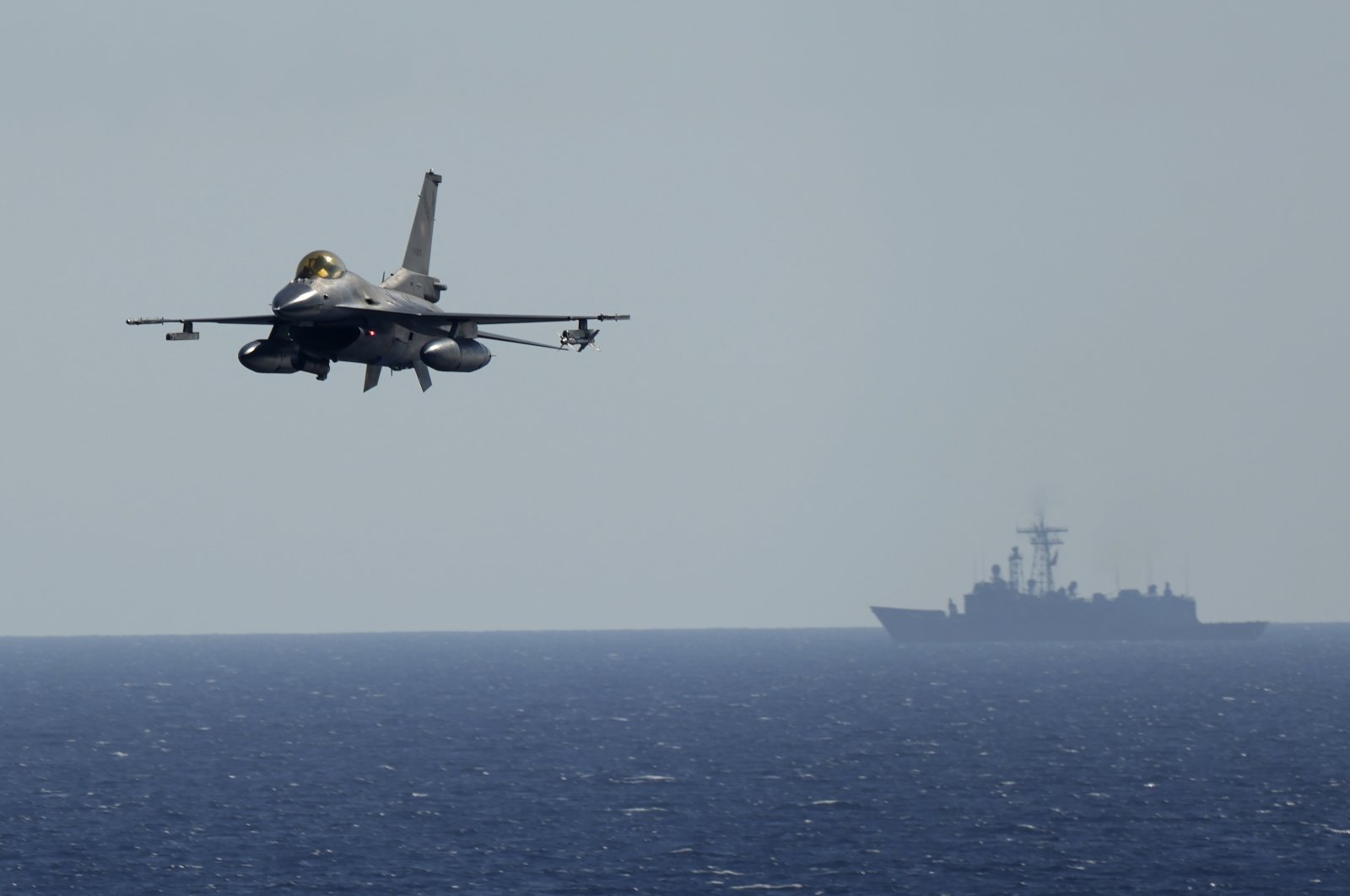 A Turkish F16 fighting jet flies over naval ships during an annual NATO naval exercise on Türkiye&#039;s western coast off the Mediterranean, Sept. 15, 2022. (AP Photo)
