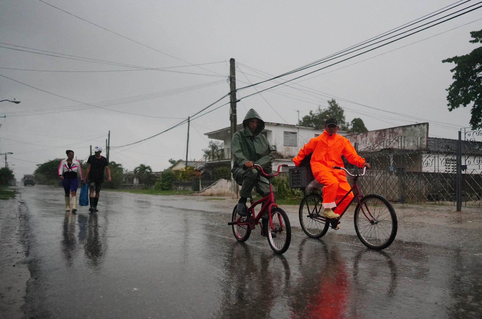 People walk under the rain ahead of the arrival of Hurricane Ian in Coloma, Cuba, September 26, 2022. REUTERS/Alexandre Meneghini ni