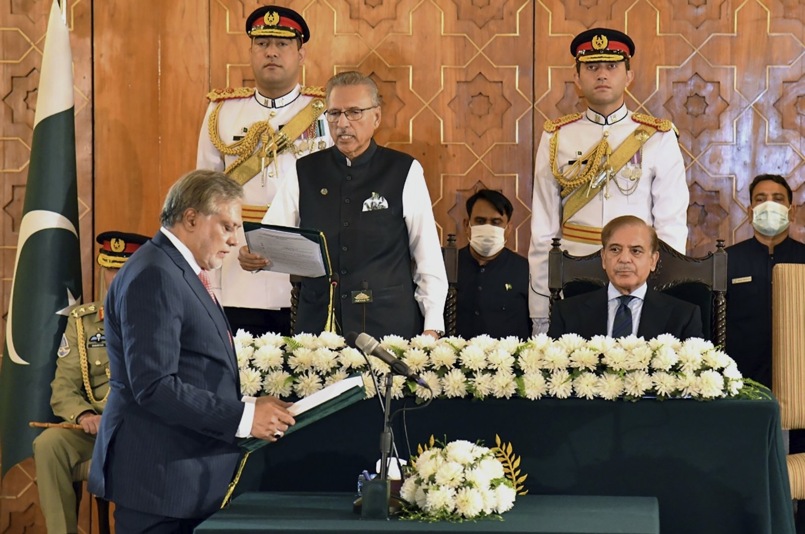 Pakistan&#039;s President Arif Alvi (C) administrates the oath from newly appointed Finance Minister Ishaq Dar (L), as Prime Minister Shahbaz Sharif (R) watches during a ceremony in Islamabad, Pakistan, Sept. 28, 2022. (Press Information Department via AP)