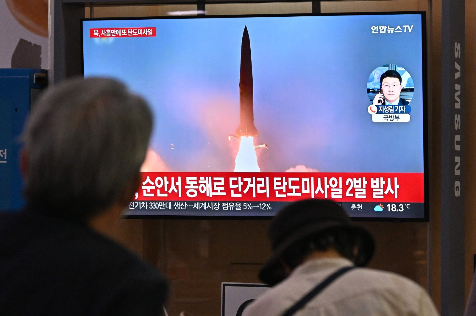People watch a television screen showing a news broadcast with file footage of a North Korean missile test, Seoul, South Korea, Sept. 28, 2022. (AFP Photo)