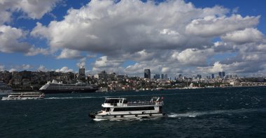 A tourist boat sails in the Bosporus as a cruise ship is docked at Galataport in Istanbul, Türkiye, Sept. 5, 2022. (Reuters Photo)