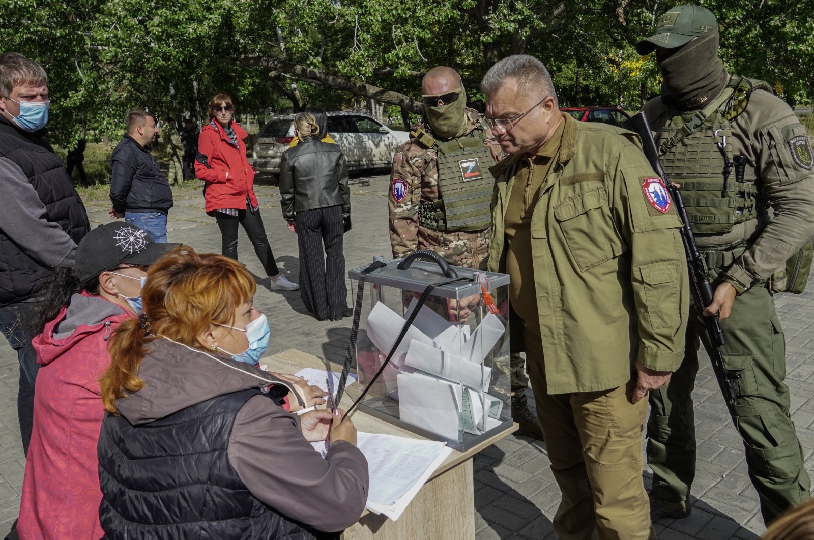 Mayor of Mariupol Konstantin Ivashchenko (2nd R) stands near armed servicemen as he speaks with members of the local election commission during voting in a referendum on the joining of Russia, Mariupol, Ukraine, Sept. 25, 2022. (EPA Photo)