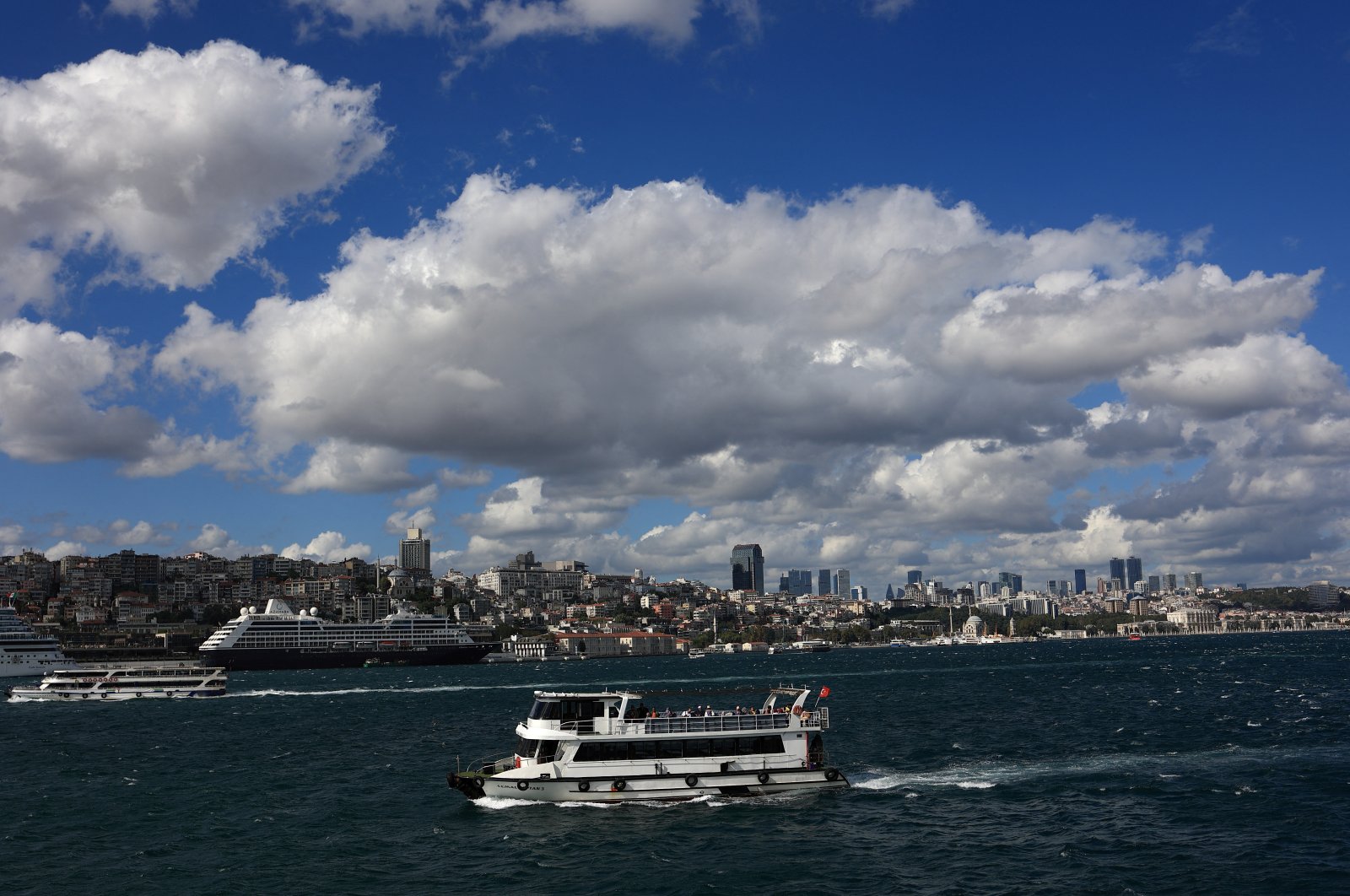 A tourist boat sails in the Bosporus as a cruise ship is docked at Galataport in Istanbul, Türkiye, Sept. 5, 2022. (Reuters Photo)
