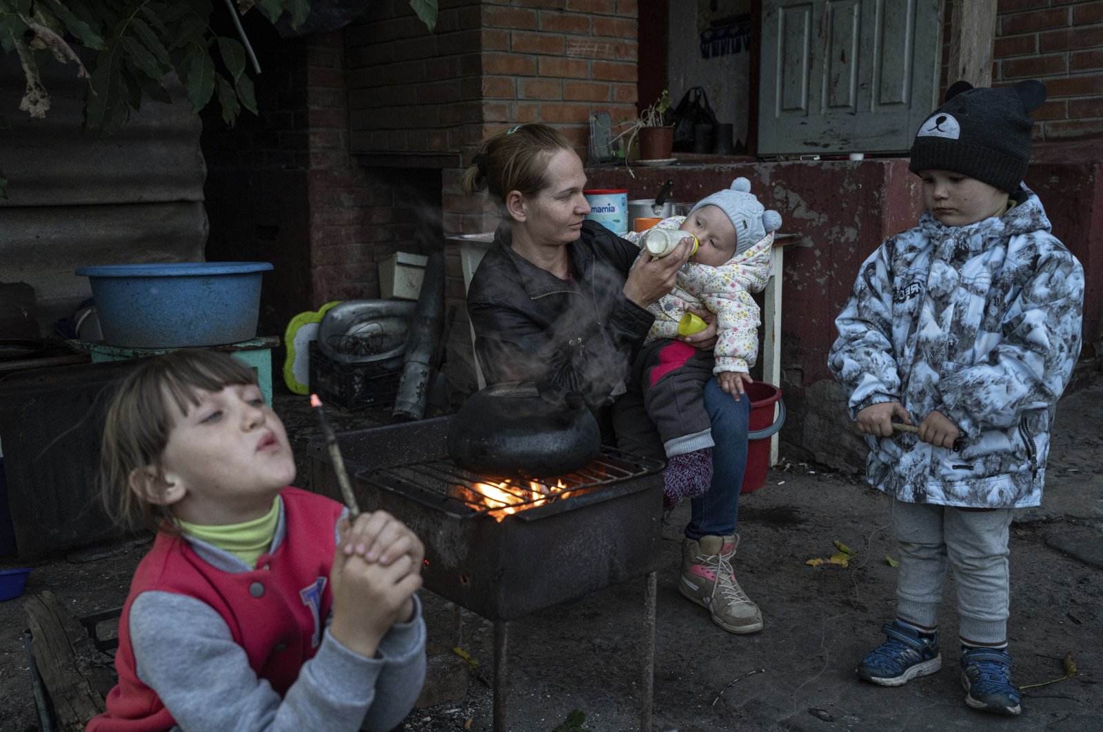 Margaryta Tkachenko feeds her 9-month-old daughter Sophia in the recently liberated town of Izium, Ukraine, Sept. 25, 2022. (AP Photo)