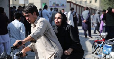 A woman arrives on a motorbike to search for a relative at a hospital after a blast in a learning center in the Dasht-e-Barchi area of Afghanistan's capital. Kabul, Sept. 30, 2022 (AFP Photo)